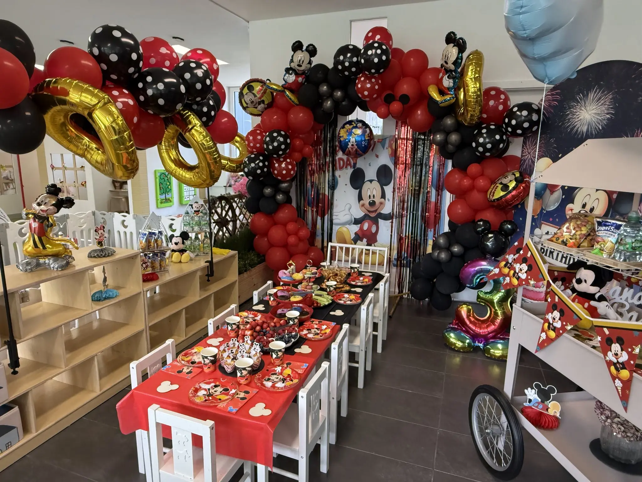 Micky-Maus-Geburtstagsdekoration mit Ballonbogen und festlich gedeckter Tafel im BAAM Kids Village