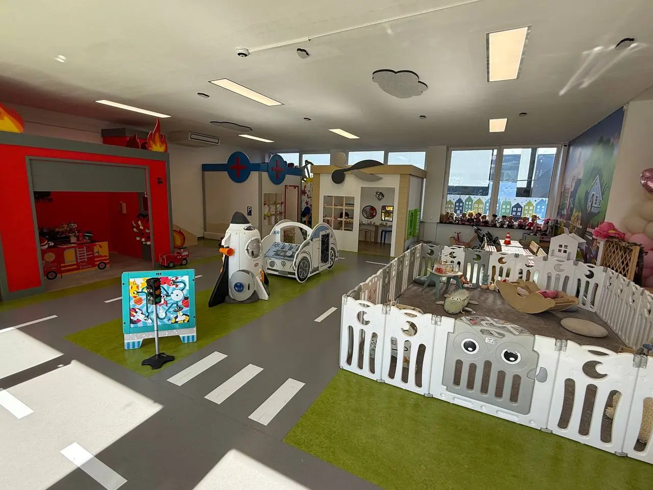 Helle Gesamtübersicht der BAAM Indoor-Spielstadt mit Feuerwehr, Arztpraxis und Babybereich